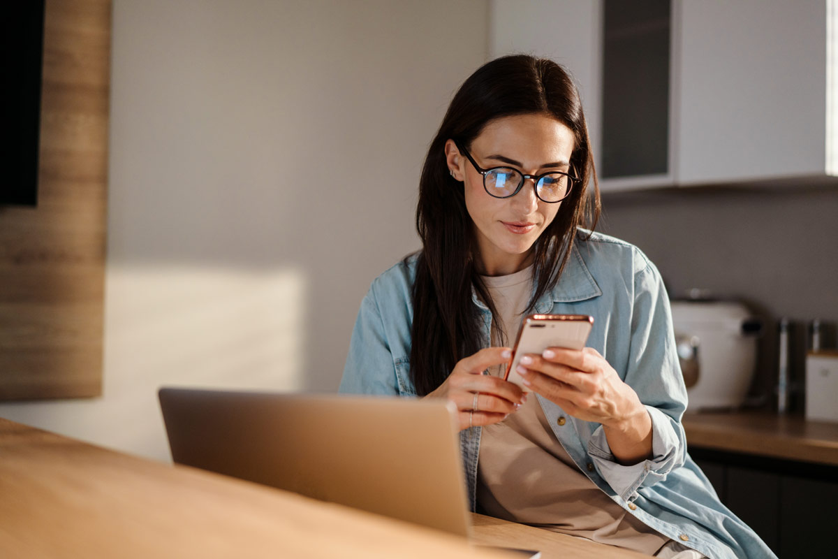 women working a home from a garden office using mobile phone and laptop